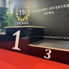 Melns apbalvošanas podests (pjedestāls) ar trim pakāpieniem, godalgoto vietu laureātiem
